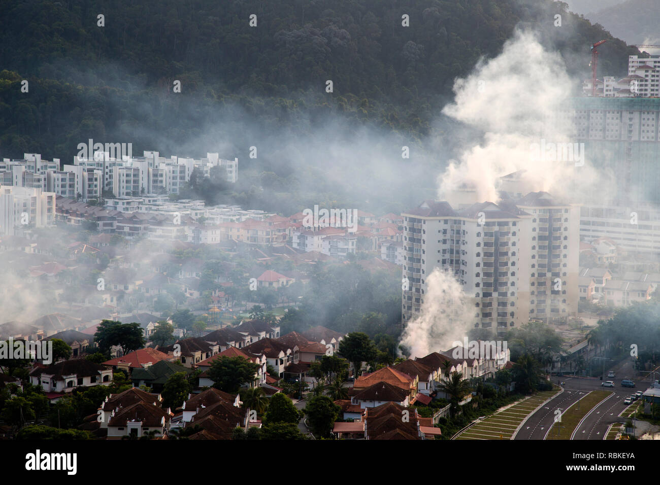 Spraying insecticide smoke known as mosquito fogging to prevent the spread of dengue fever in Batu Ferringhi on Penand Island, Malaysia. Stock Photo