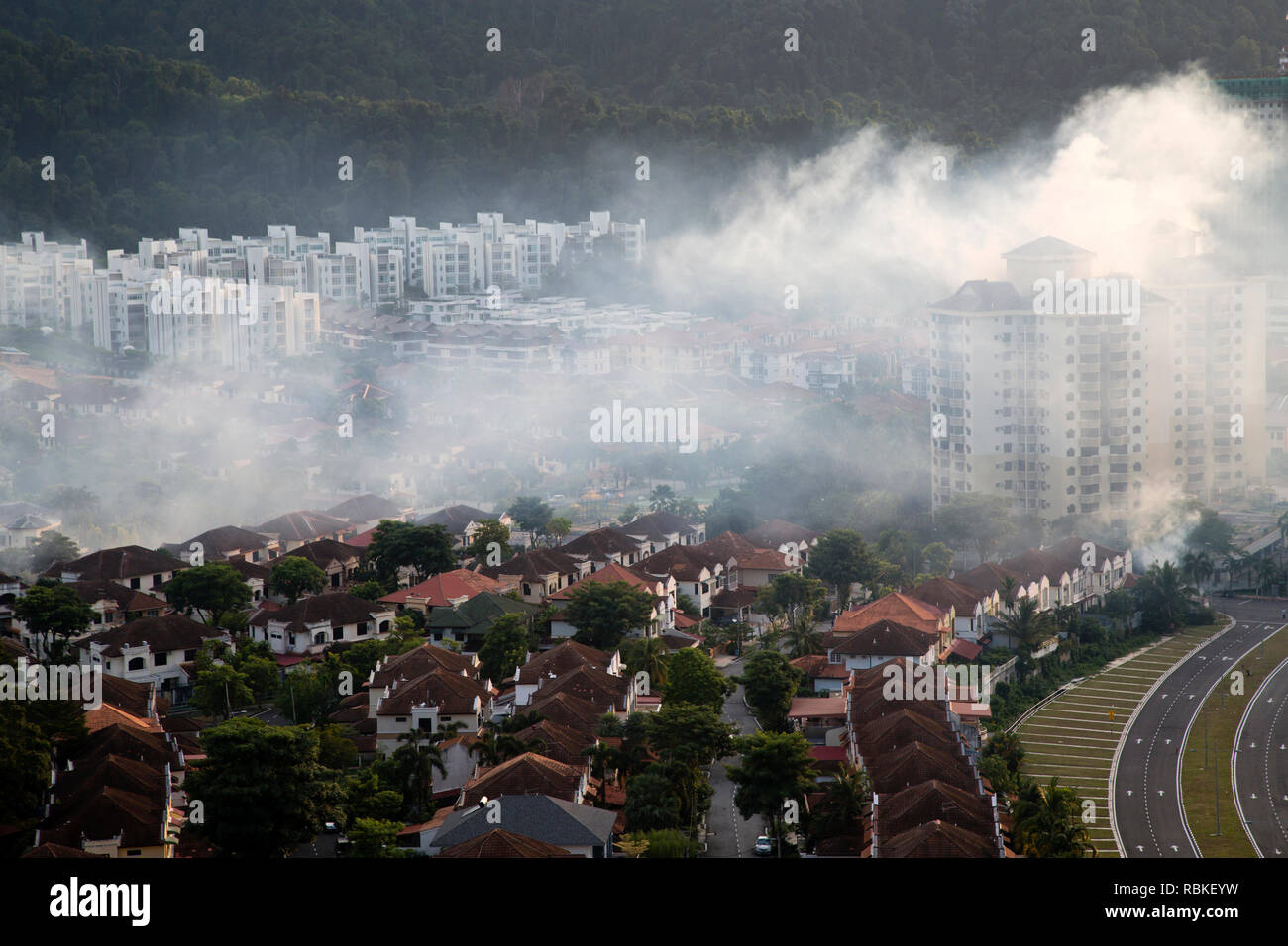 Spraying insecticide smoke known as mosquito fogging to prevent the spread of dengue fever in Batu Ferringhi on Penand Island, Malaysia. Stock Photo