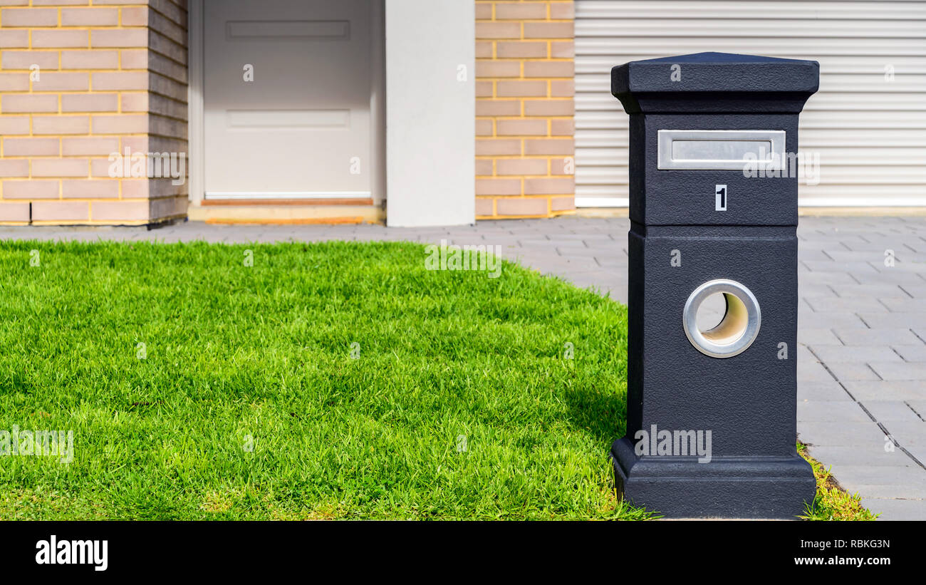 Brand new Australian house freestanding mailbox on the green lawn at front yard Stock Photo