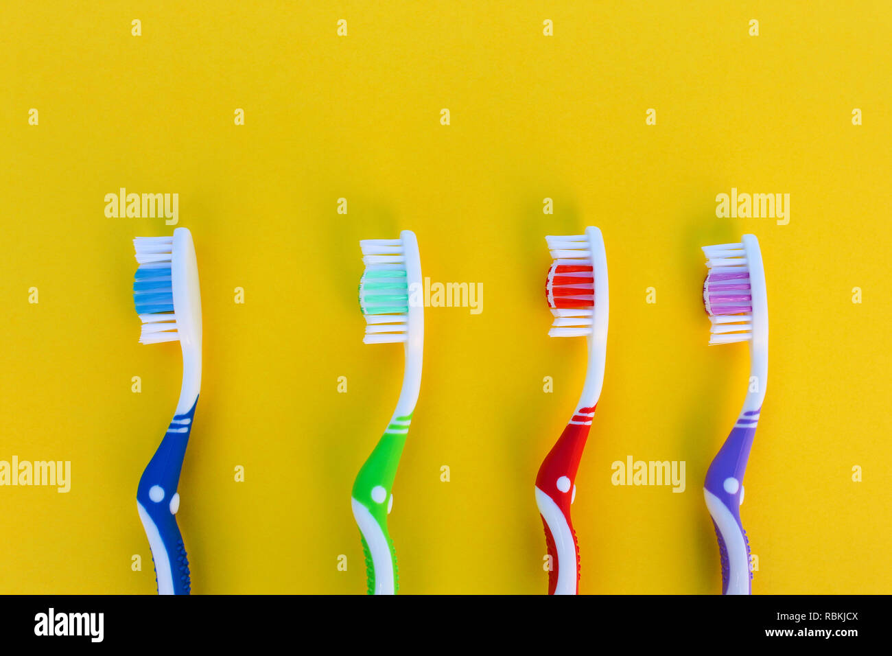Toothbrushes on yellow background. Top view Stock Photo - Alamy