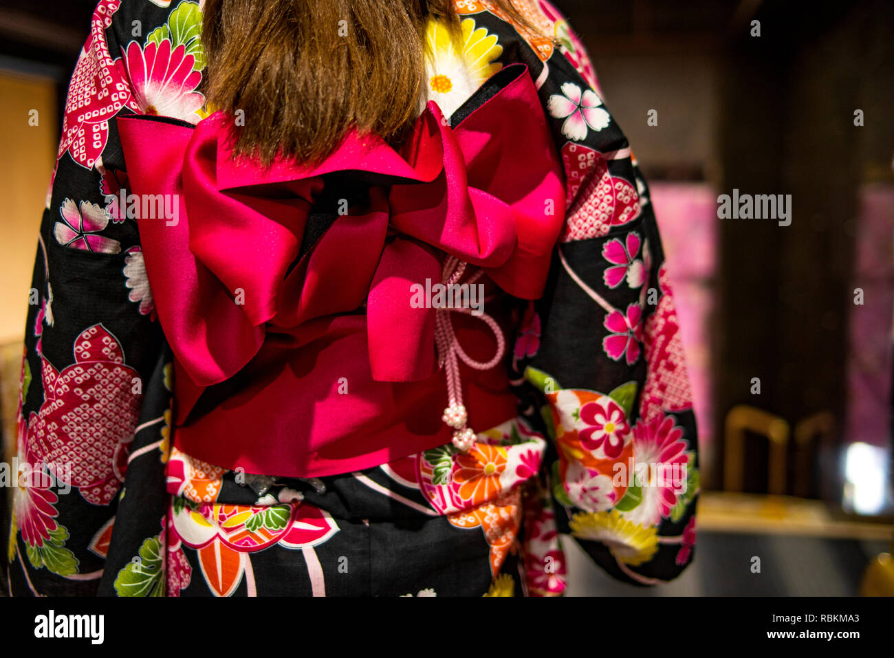 Pink ribbon on Japanese traditional clothes of Kimono.Dressing kimono. Young girl wearing