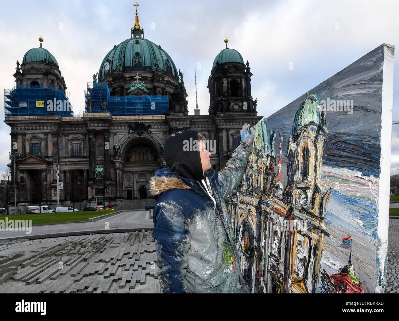 Berlin, Germany. 10th Jan, 2019. The painter Christopher Lehmpfuhl paints a picture with the Berlin Cathedral in the Lustgarten. The artist is known for painting large-format, color-intensive pictures in public or outdoors. He uses his fingers to apply the paint. Credit: Jens Kalaene/dpa-Zentralbild/ZB/dpa/Alamy Live News Stock Photo