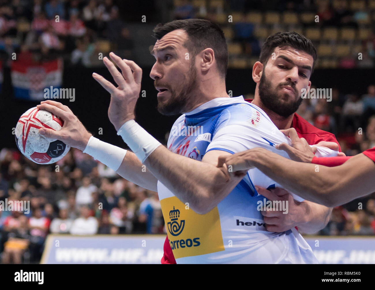 11 January 2019, Bavaria, München: Handball: World Championship, Bahrain - Spain, preliminary round, Group B, 1st matchday in the Olympic Hall. Gedeon Guardiola (l) of Spain in action against Hasan Madan of Bahrain. Photo: Sven Hoppe/dpa Stock Photo