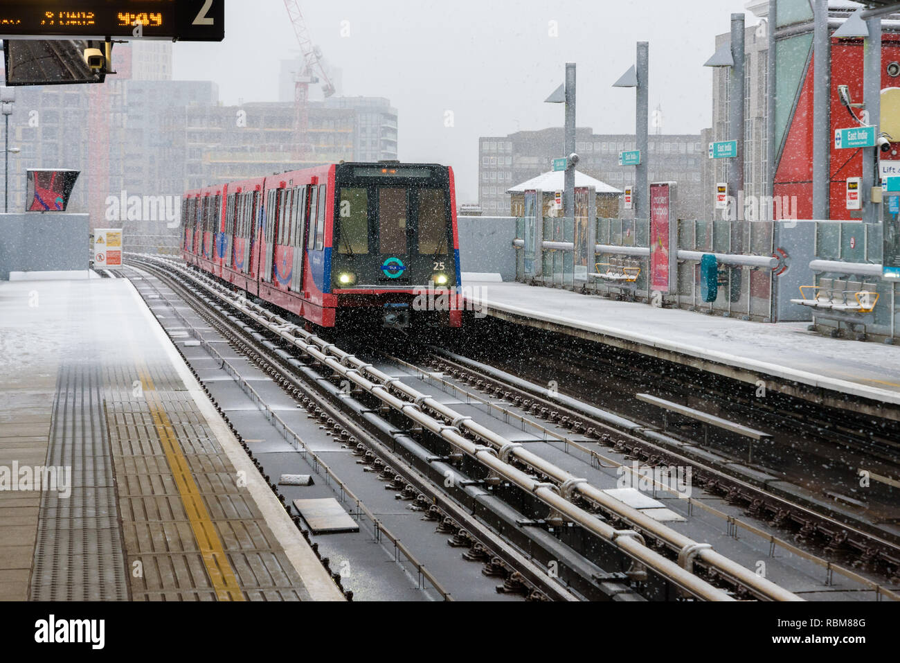 Snow falling on a DLR train approaching East India station in Poplar, London, England. Stock Photo
