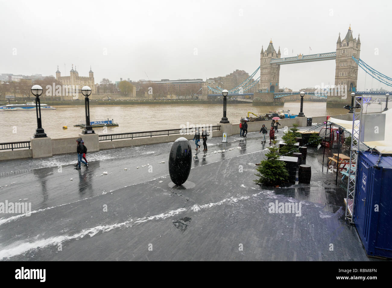 Snow at London Bridge City riverside on the Thames. Tower Bridge in the background Stock Photo
