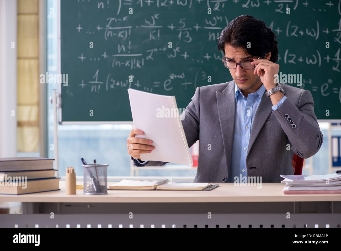 Young handsome math teacher in classroom Stock Photo
