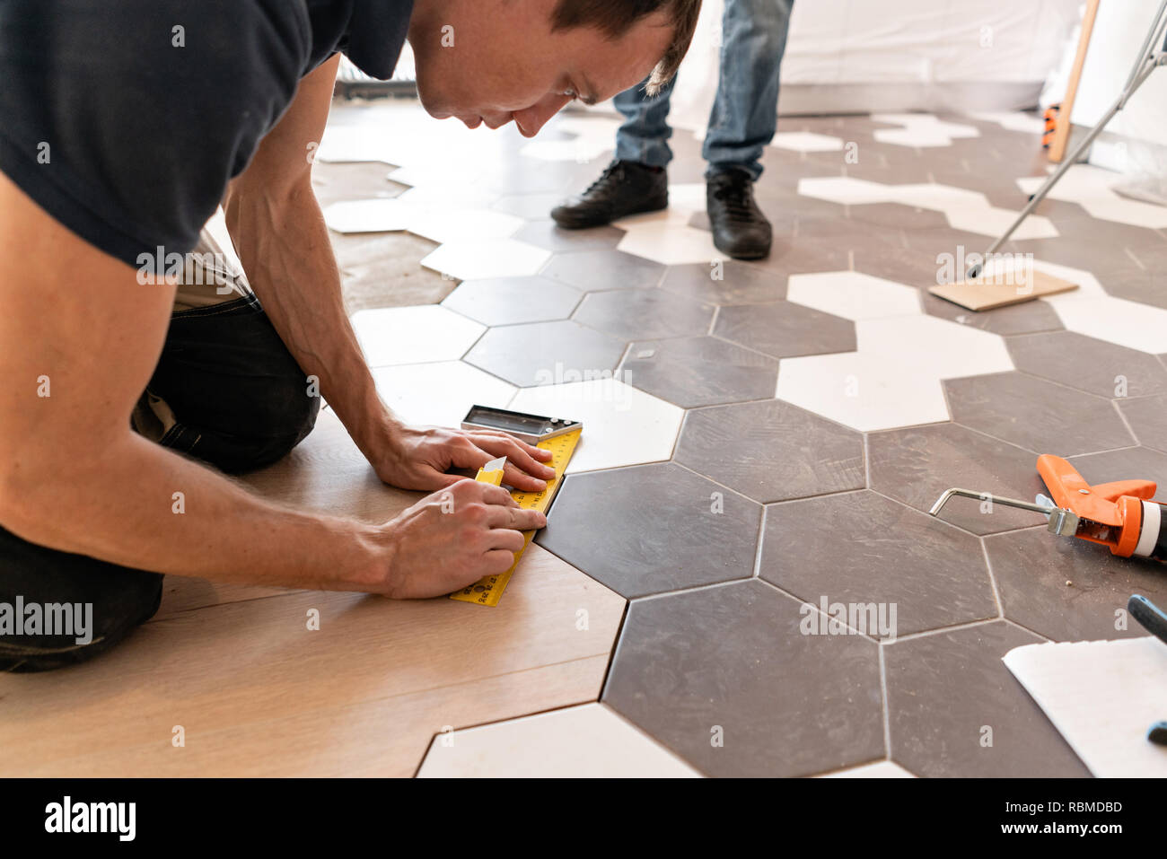 Male Worker Installing New Wooden Laminate Flooring The