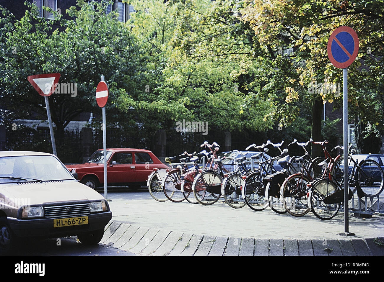 Bicycles Parked Car On Street With Road Signs Amsterdam Netherlands Stock Photo Alamy
