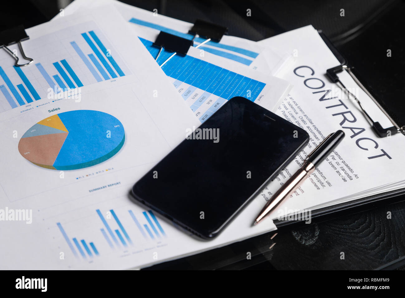 mobile phone lies on stack of financial documents and contract on ...