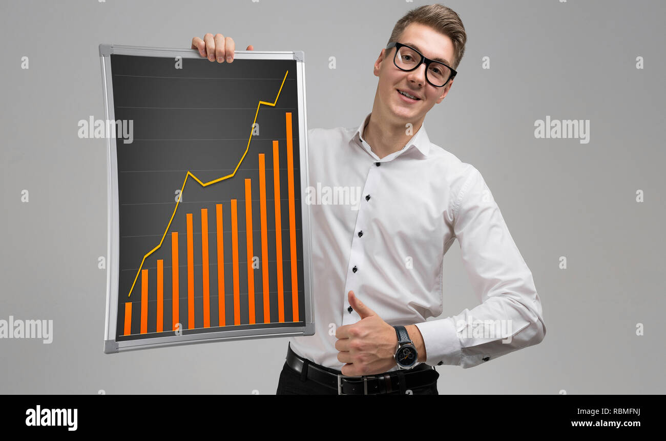 Young man shows class sign and keeps rising graph isolated on white ...