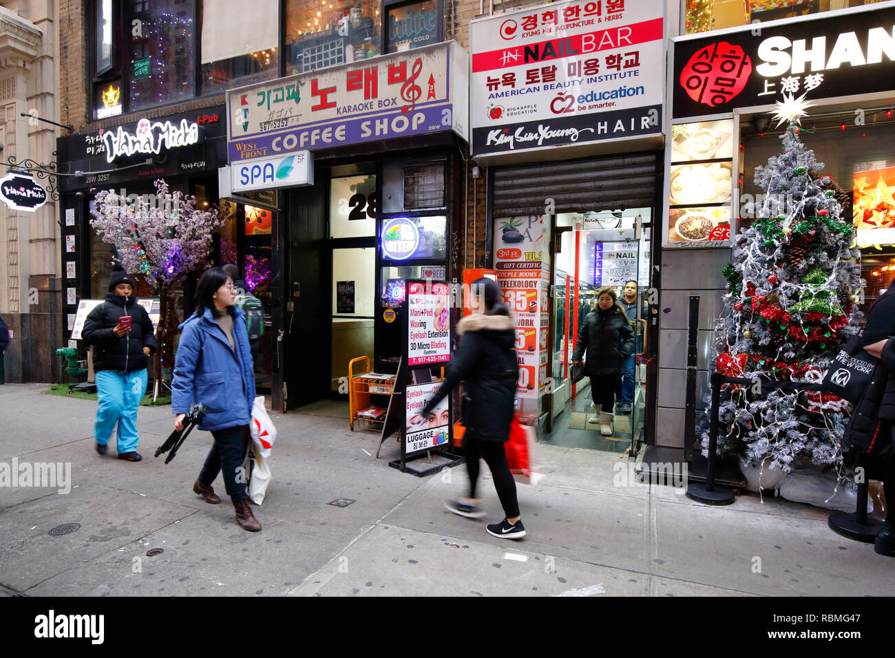 People walking past shops and restaurants in Koreatown in Manhattan, New York, NY. (December 19, 2018) Stock Photo