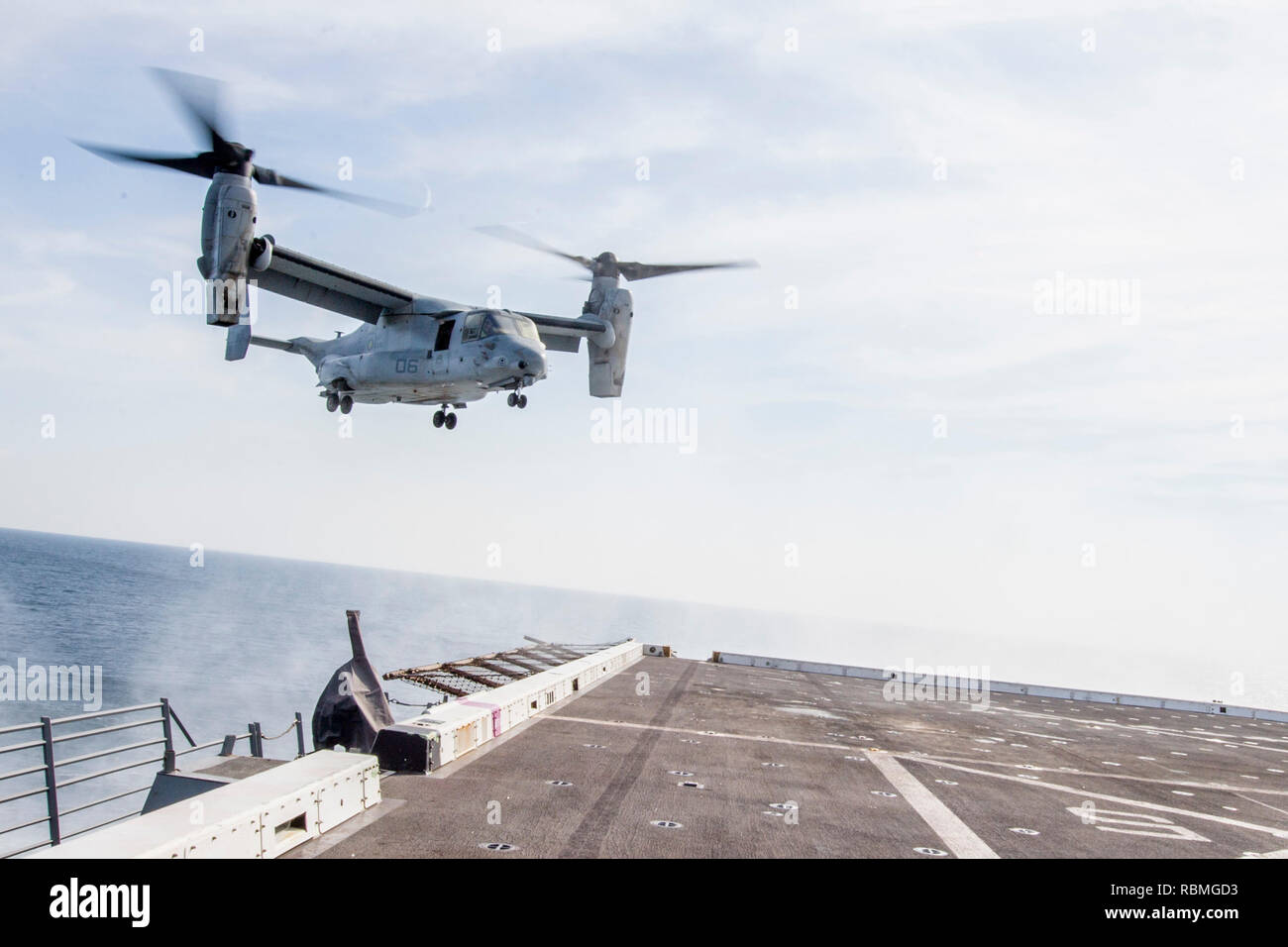 190102-N-PH222-1095 ARABIAN SEA (Jan. 2, 2018) An MV-22 Osprey tiltrotor aircraft, attached to Marine Medium Tiltrotor Squadron (VMM) 166 (Reinforced), prepares to land on the flight deck of the San Antonio-class amphibious transport dock ship USS Anchorage (LPD 23). Anchorage is on a deployment of the Essex Amphibious Ready Group (ARG) and 13th Marine Expeditionary Unit (MEU). The Essex ARG/13th MEU is flexible and persistent Navy-Marine Corps team deployed to the U.S. 5th Fleet area of operations in support of naval operations to ensure maritime stability and security in the Central Region,  Stock Photo