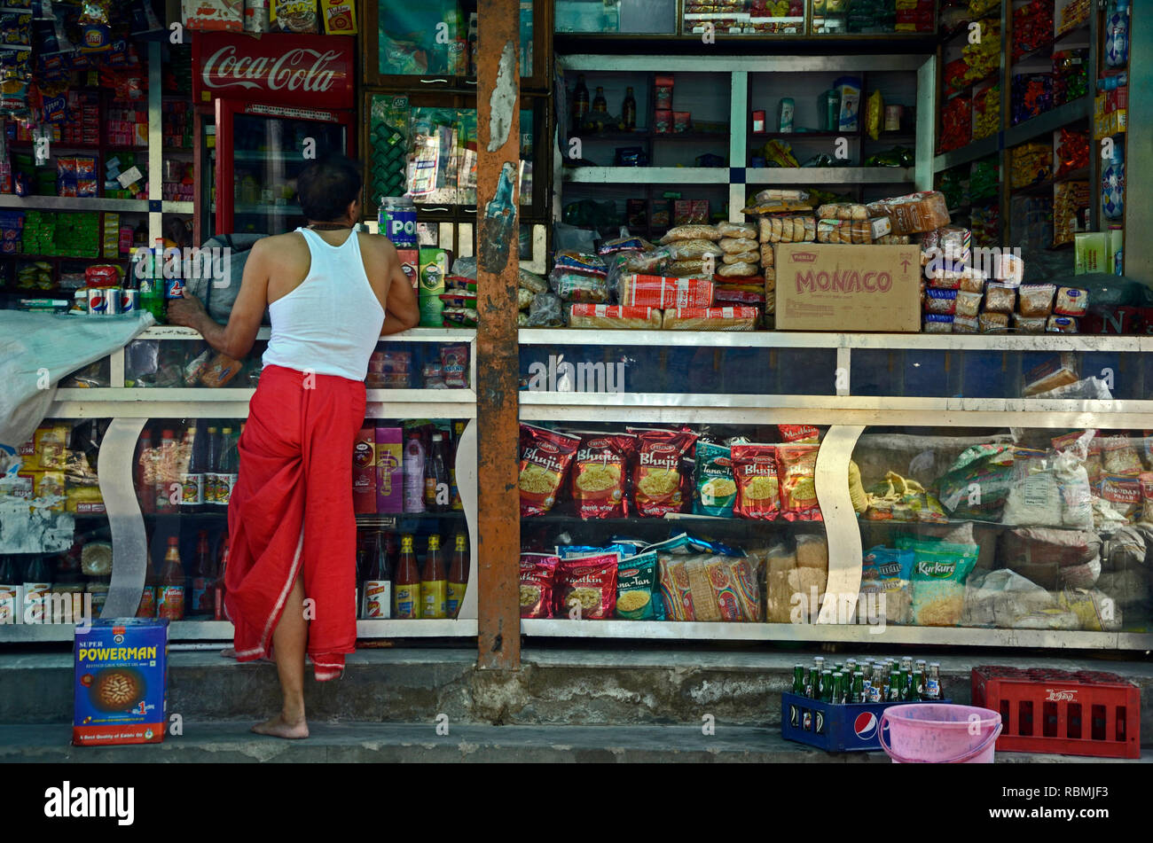 Man in red Dhoti buying at general store, Jodhpur, Rajasthan, India, Asia Stock Photo