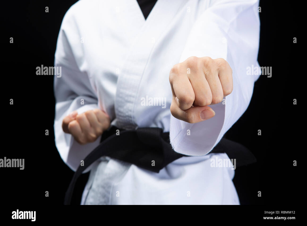 Fist of woman in karate suit on black background Stock Photo - Alamy