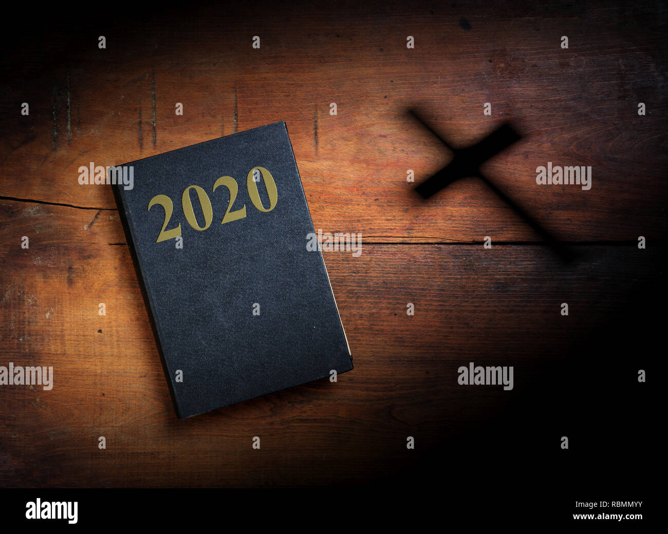 2020 New year and christianity. Holy Bible with 2020 text and cross on wooden background. 3d illustration Stock Photo