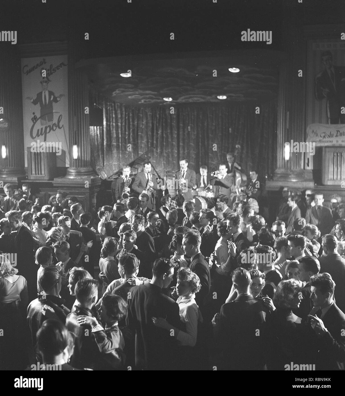 Dancing in the 1950s. The dance floor is filled with well dressed dancing  couples, moving to the music at a club. A band is playing on stage. Nalen Stockholm Sweden 1955. BV40-4 Stock Photo