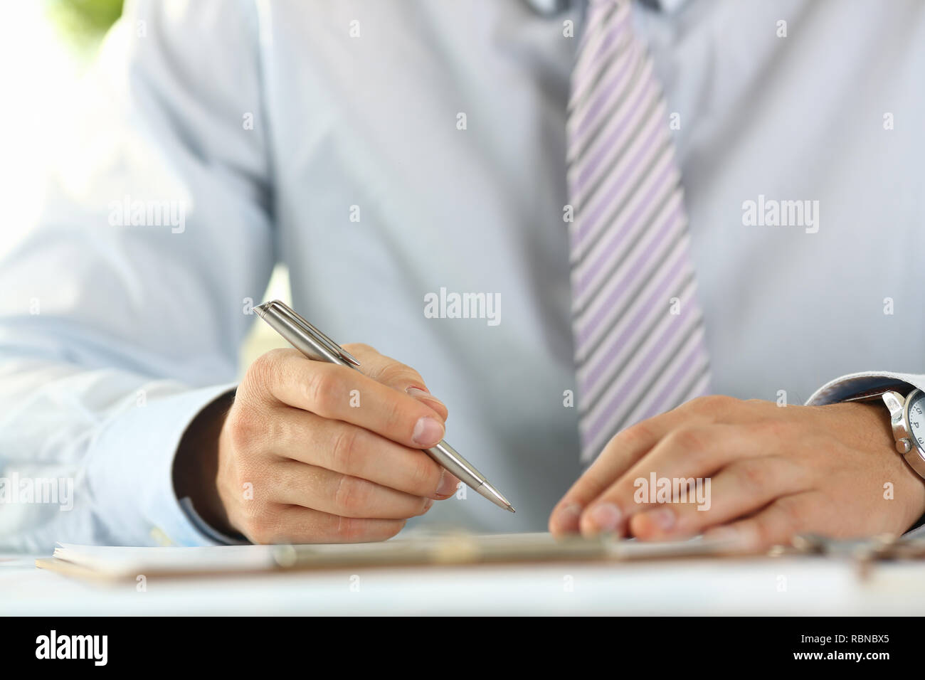 Male arm in suit and tie hold silver Stock Photo