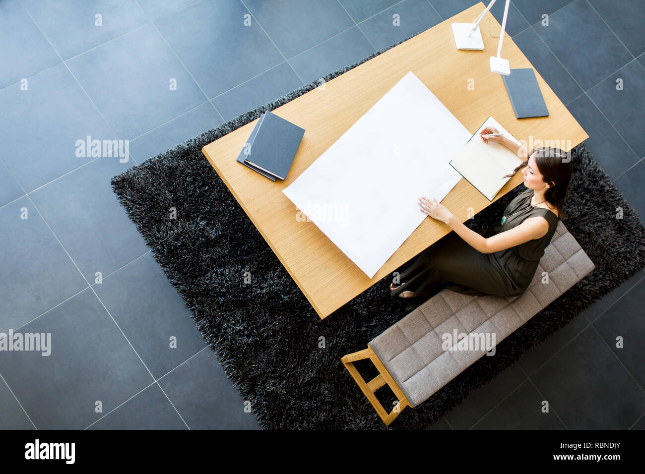 View at young female architect working on a project Stock Photo