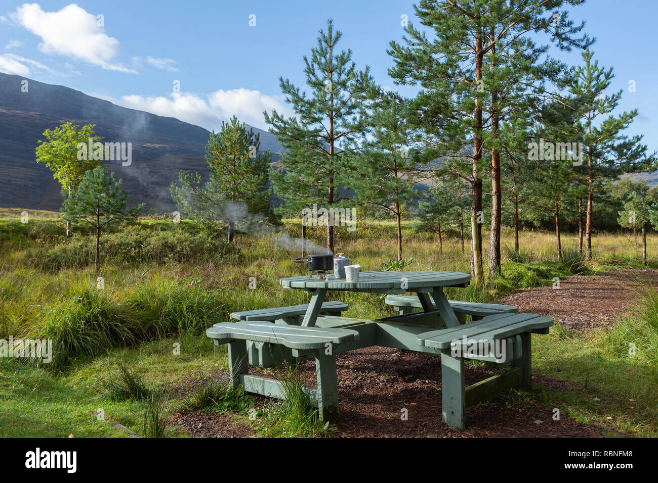 Breakfast being prepared on a camping stove mounted on a picnic table, near Torridon village, Scotland Stock Photo