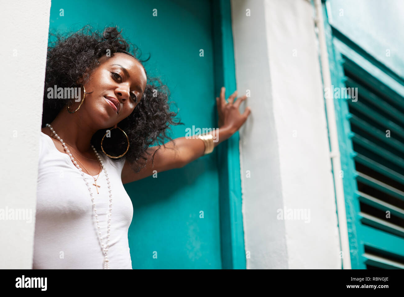 Young black woman leaning in a doorway, low angle, close up Stock Photo