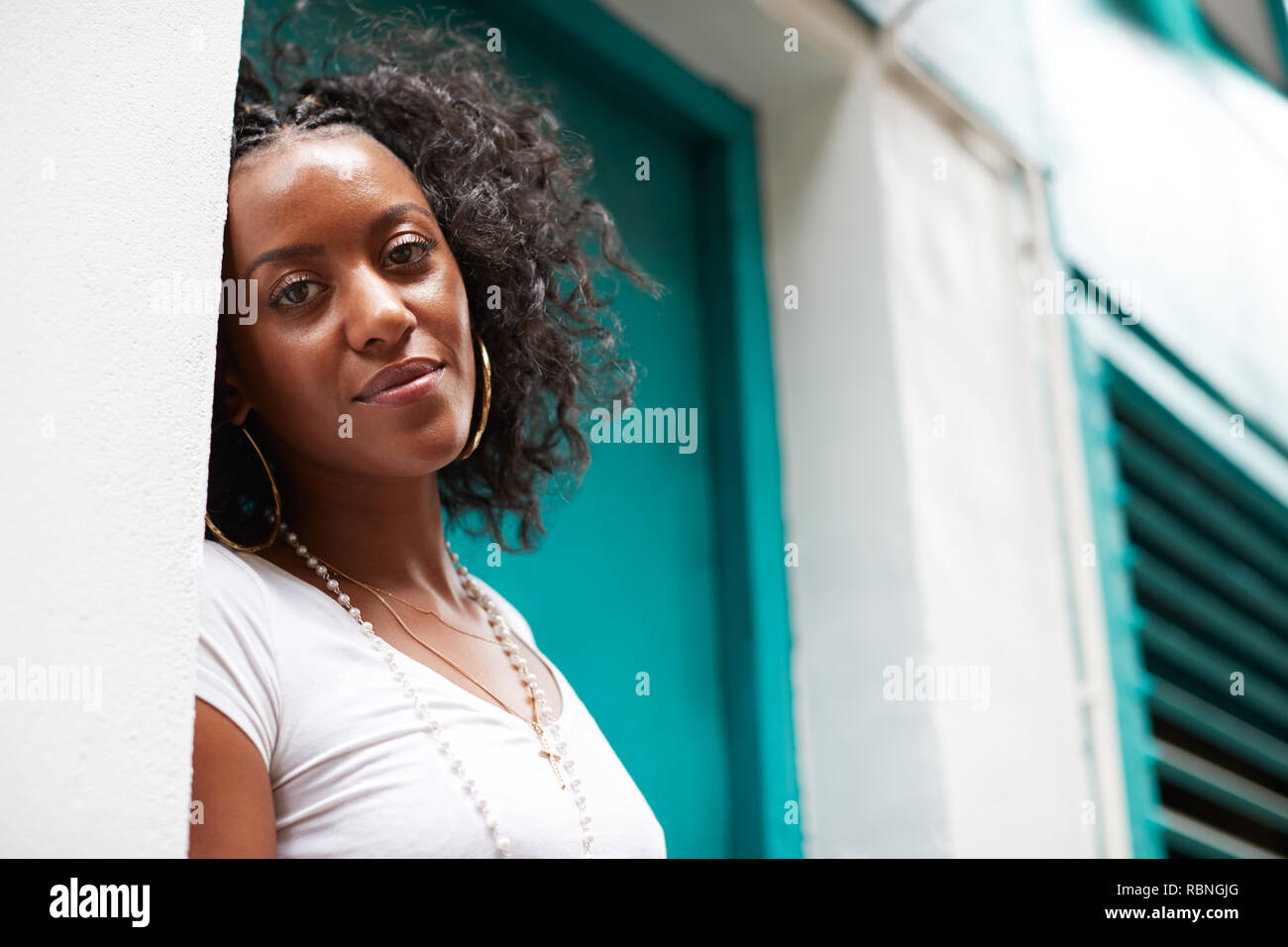 Young black woman in doorway smiling to camera, close up Stock Photo