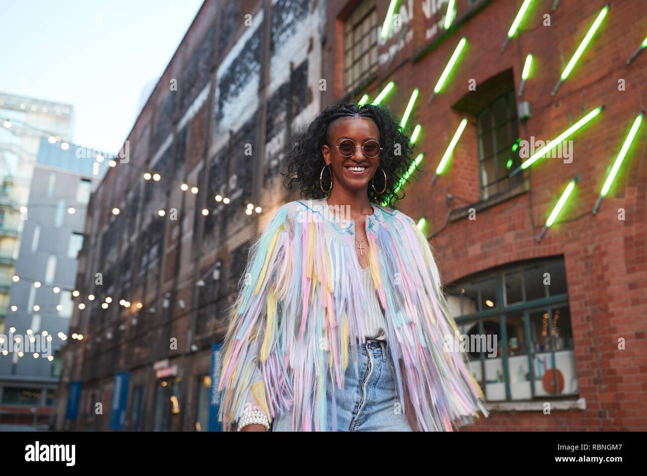 Trendy woman in striped camisole and fringed jacket Stock Photo