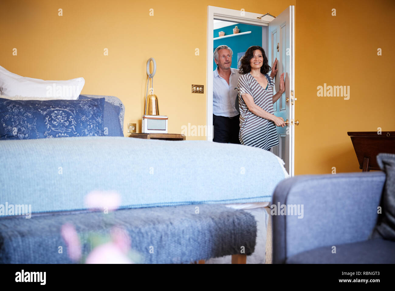 Middle aged couple opening the door to their hotel room Stock Photo