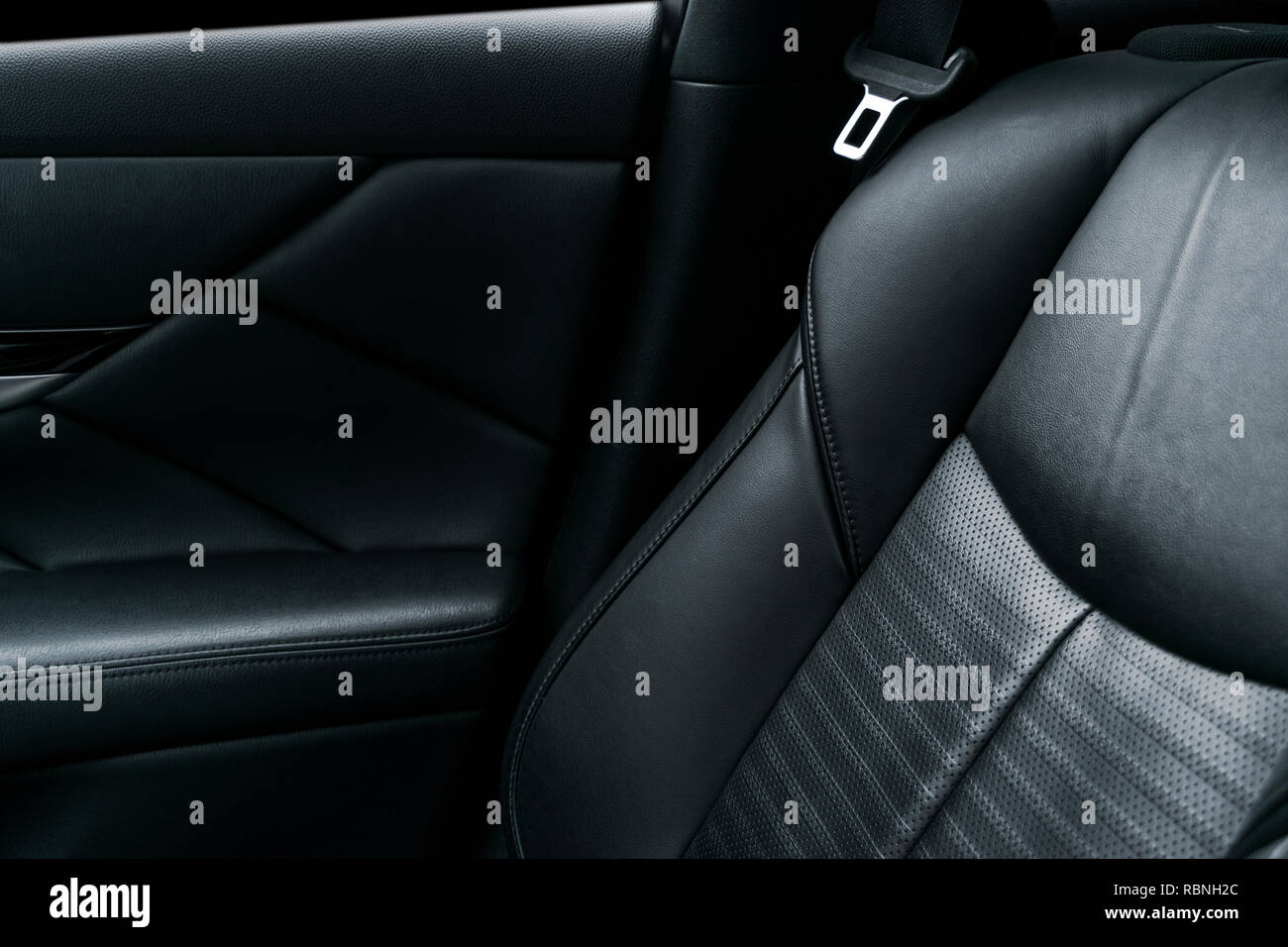 Modern luxury car black perforated leather interior. Part of leather car seat details. Modern