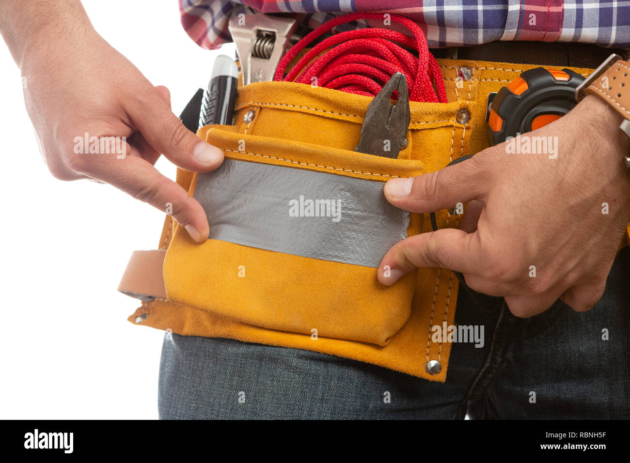 Close-up of male builder fixing waist tool belt pocket with grey ducktape isolated on white background Stock Photo