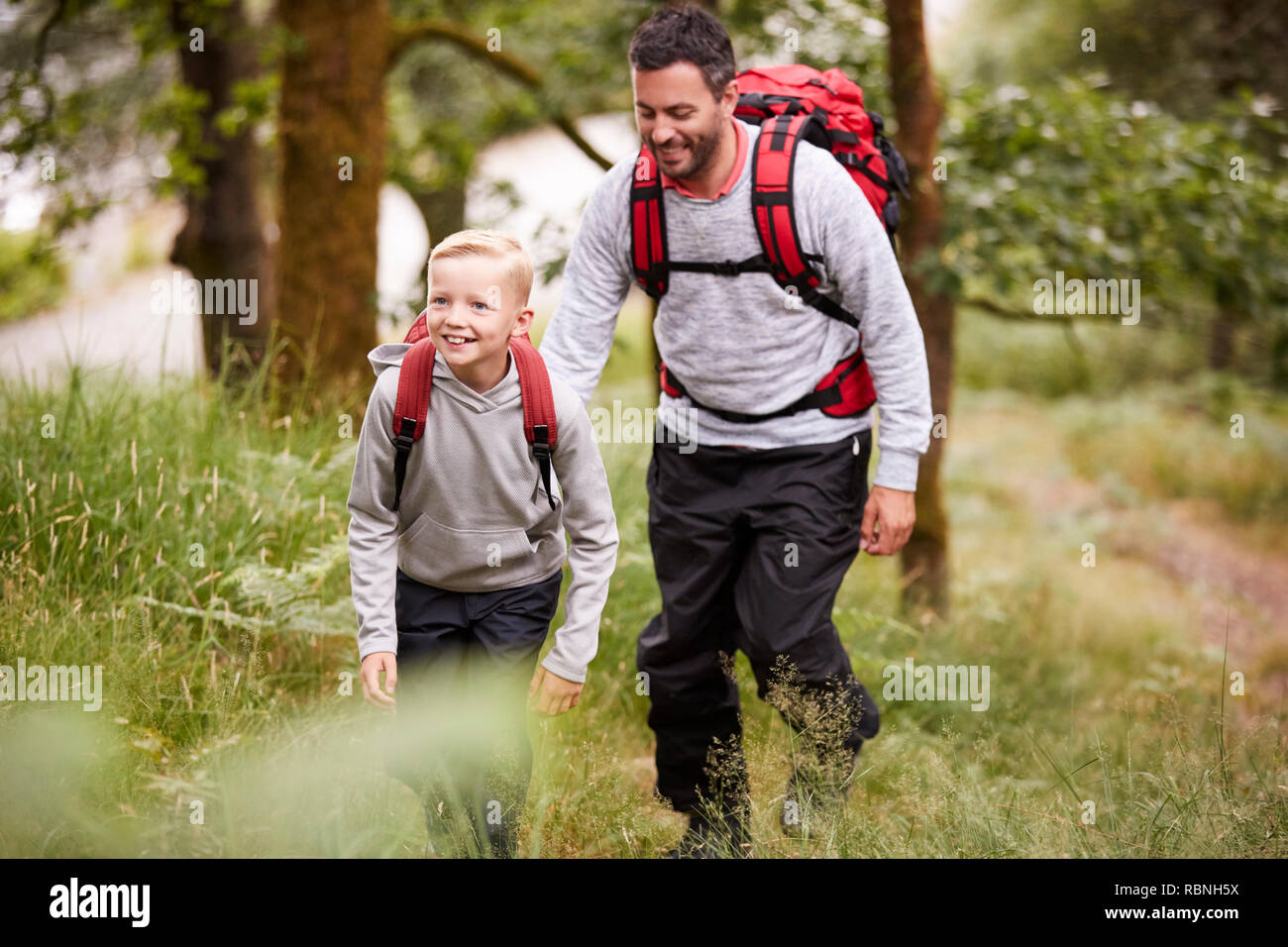 Pre-teen boy and his father hiking in a forest, selective focus Stock Photo