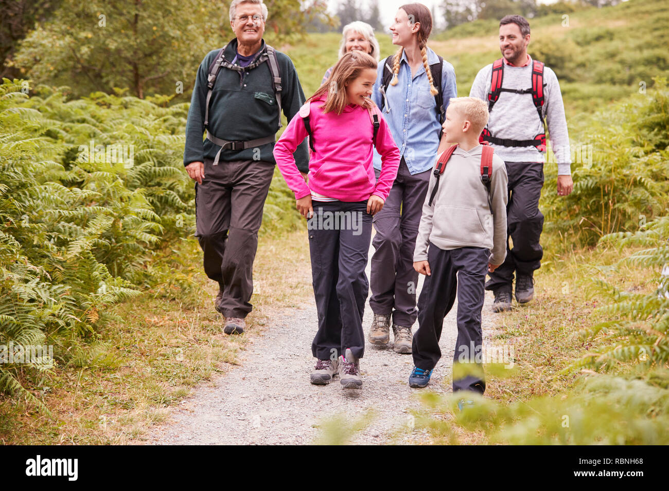 Multi generation family talk while walking in the countryside during a camping holiday, full length Stock Photo