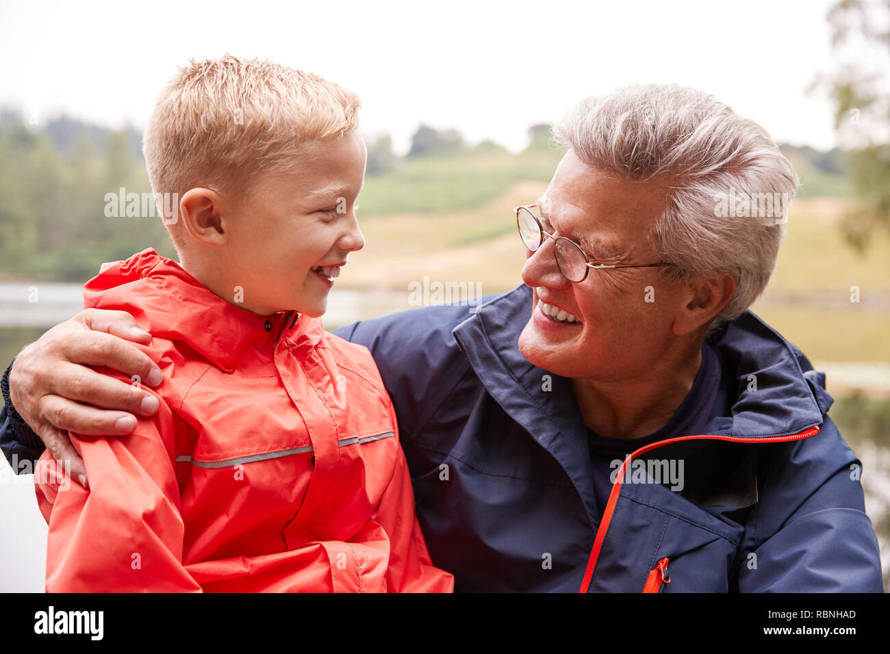 Close up of grandson and his grandfather in the countryside looking at each other, portrait, Lake District, UK Stock Photo