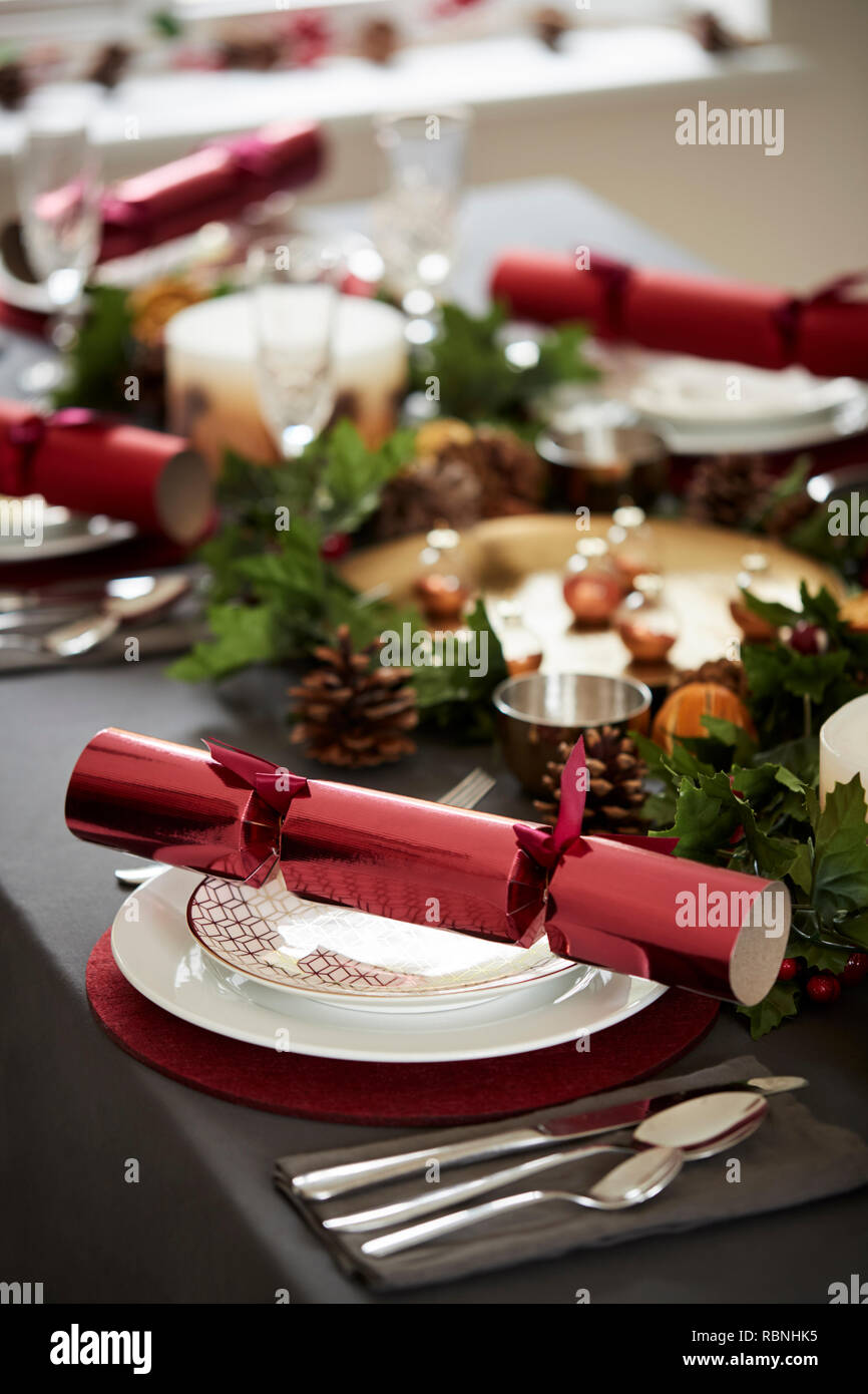Close up of decorated Christmas table setting, with centrepiece and Christmas crackers arranged on plates Stock Photo