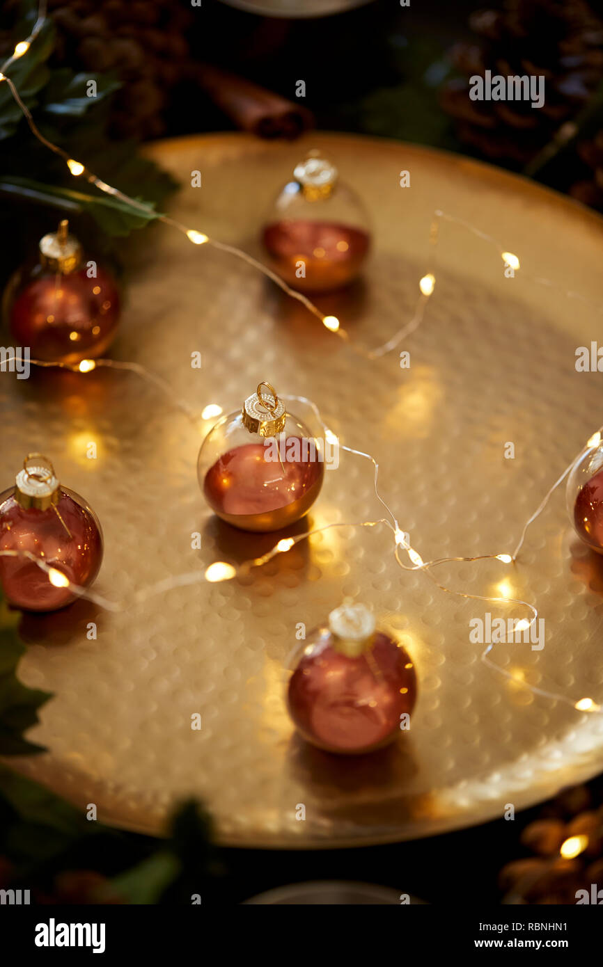 Close up of Christmas baubles on a gold table with warm glow, selective focus Stock Photo