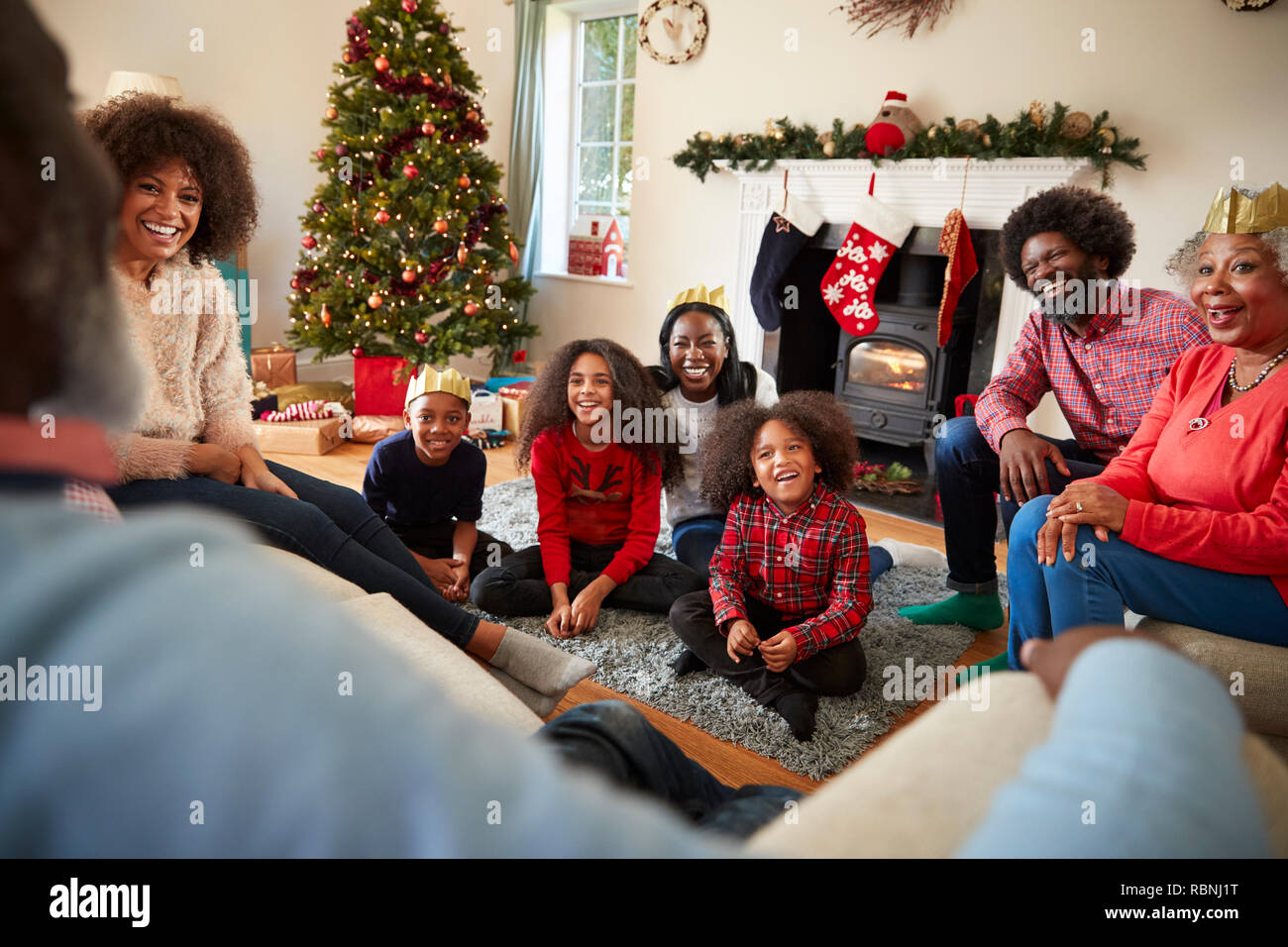Multi Generation Family Sitting In Lounge At Home On Christmas Day Stock Photo