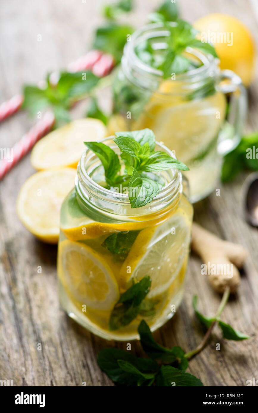 https://c8.alamy.com/comp/RBNJMC/mint-lemonade-refreshment-beverage-in-retro-mason-jars-on-rustic-wooden-table-gignger-lemon-and-herbs-ingredients-for-summer-detox-drink-recipe-RBNJMC.jpg