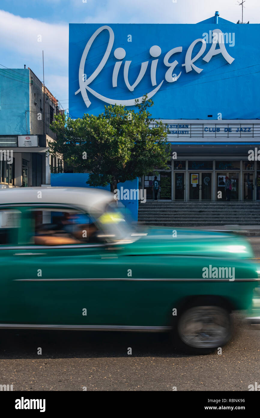 Old American car speeding past the Riviera cinema in Havana, Cuba Stock Photo