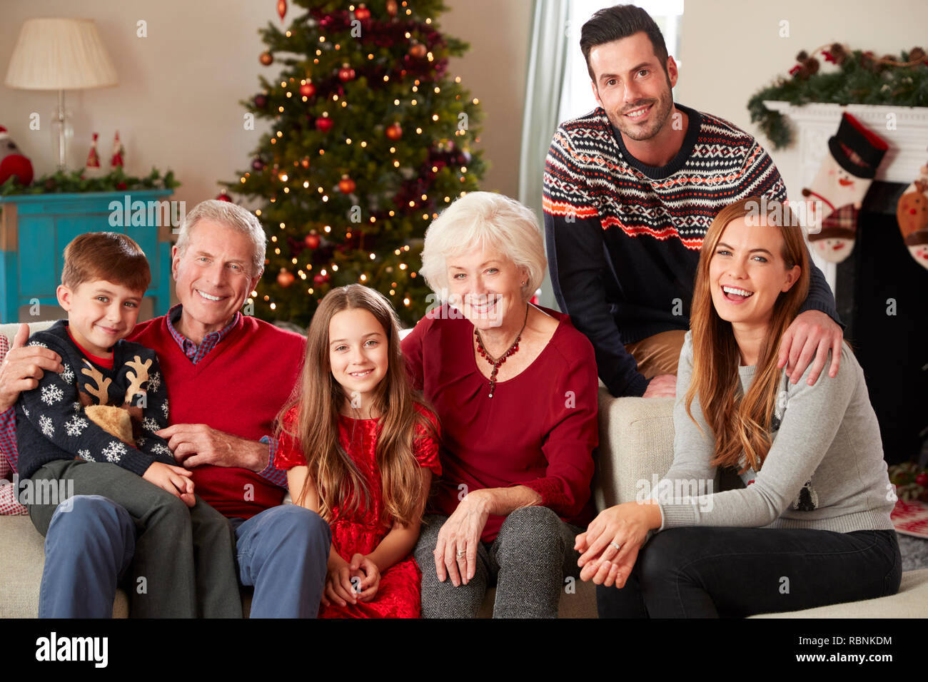 Portrait Of Multi Generation Family Sitting On Sofa In Lounge At Home On Christmas Day Stock Photo