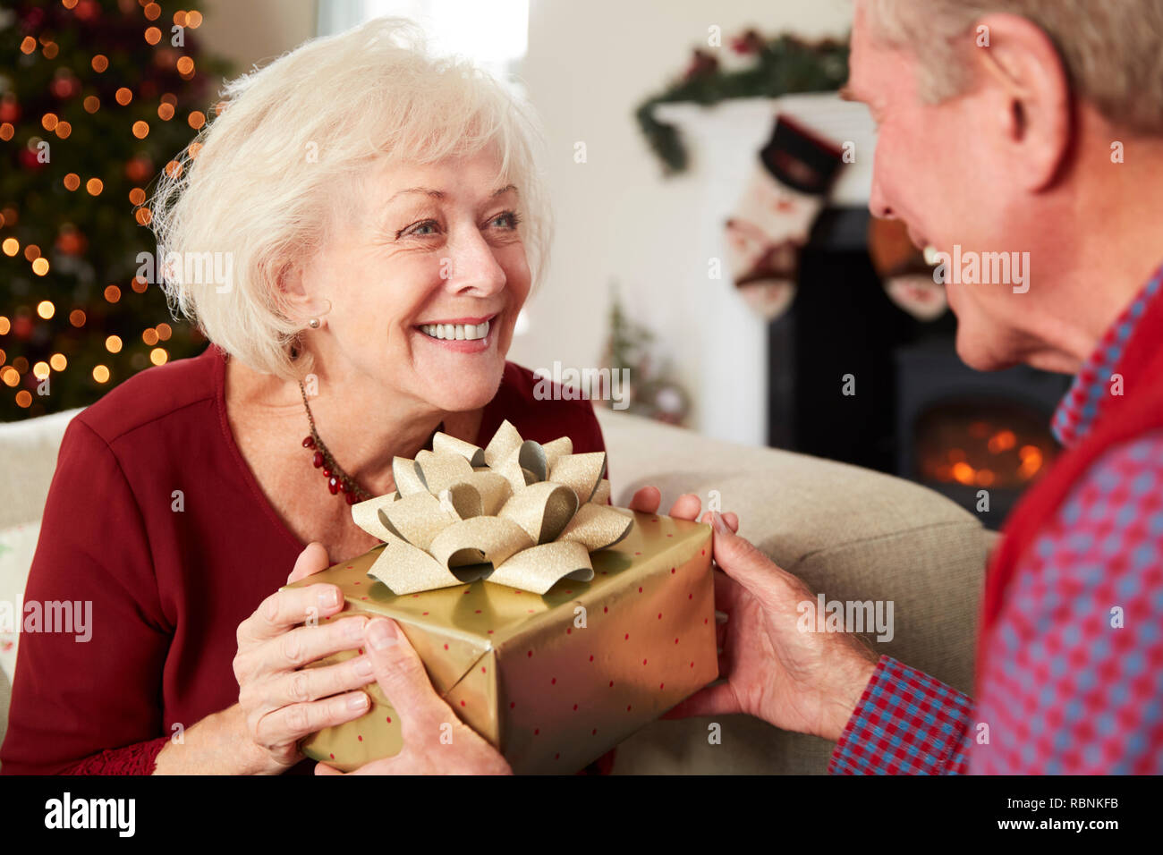 Excited Mother Receiving Christmas Gift From Daughter At Home Stock Photo