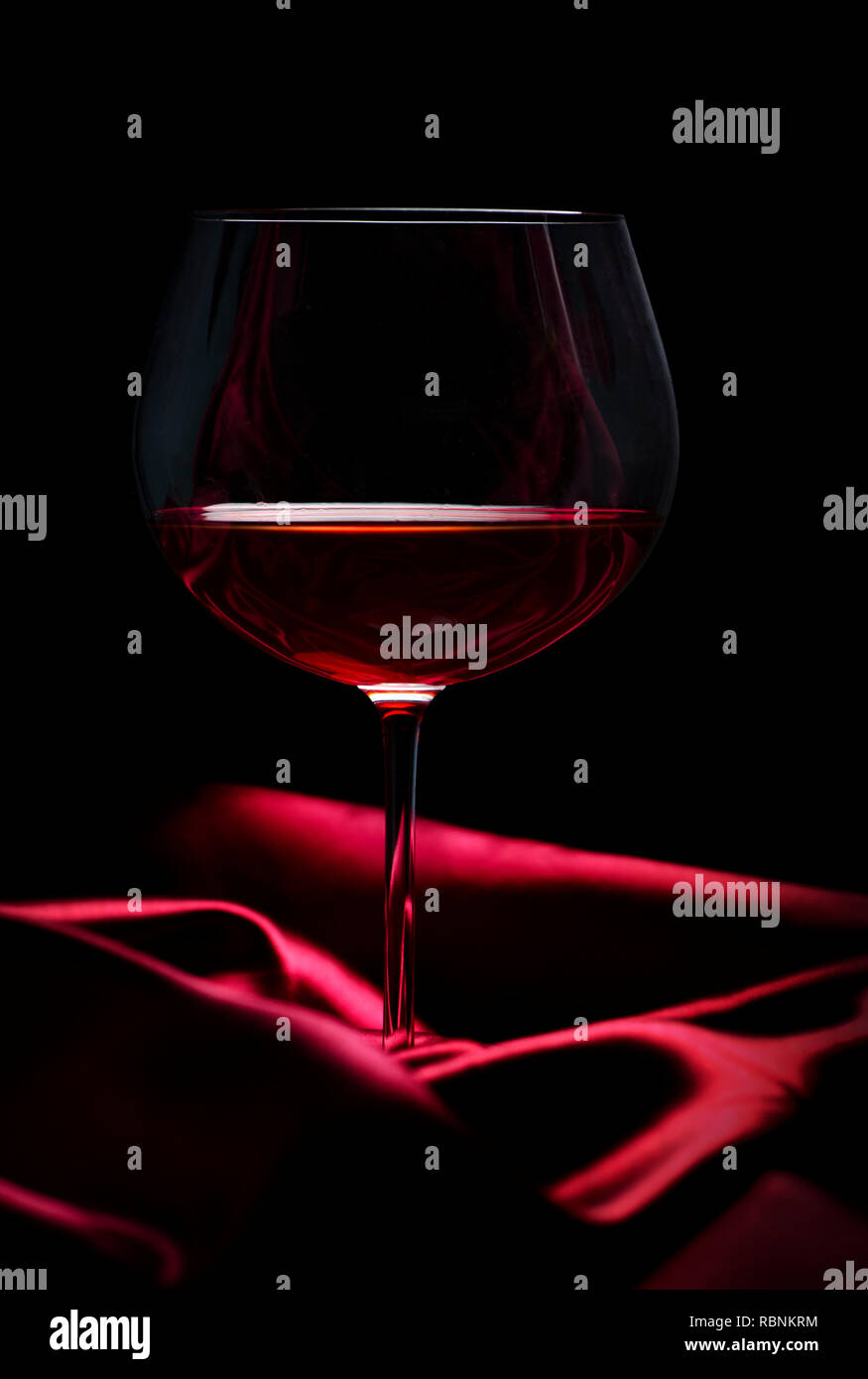 Glass of red wine on red silk against black background. Wine list design  background Stock Photo - Alamy
