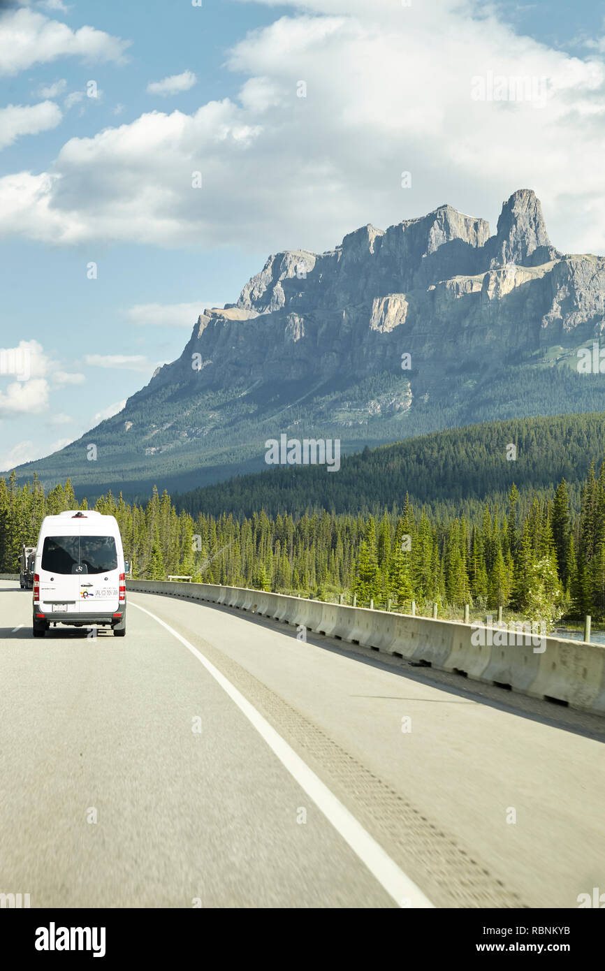 Van Driving On Country Road Through Wooded Valley Between Mountains In Alaska Stock Photo