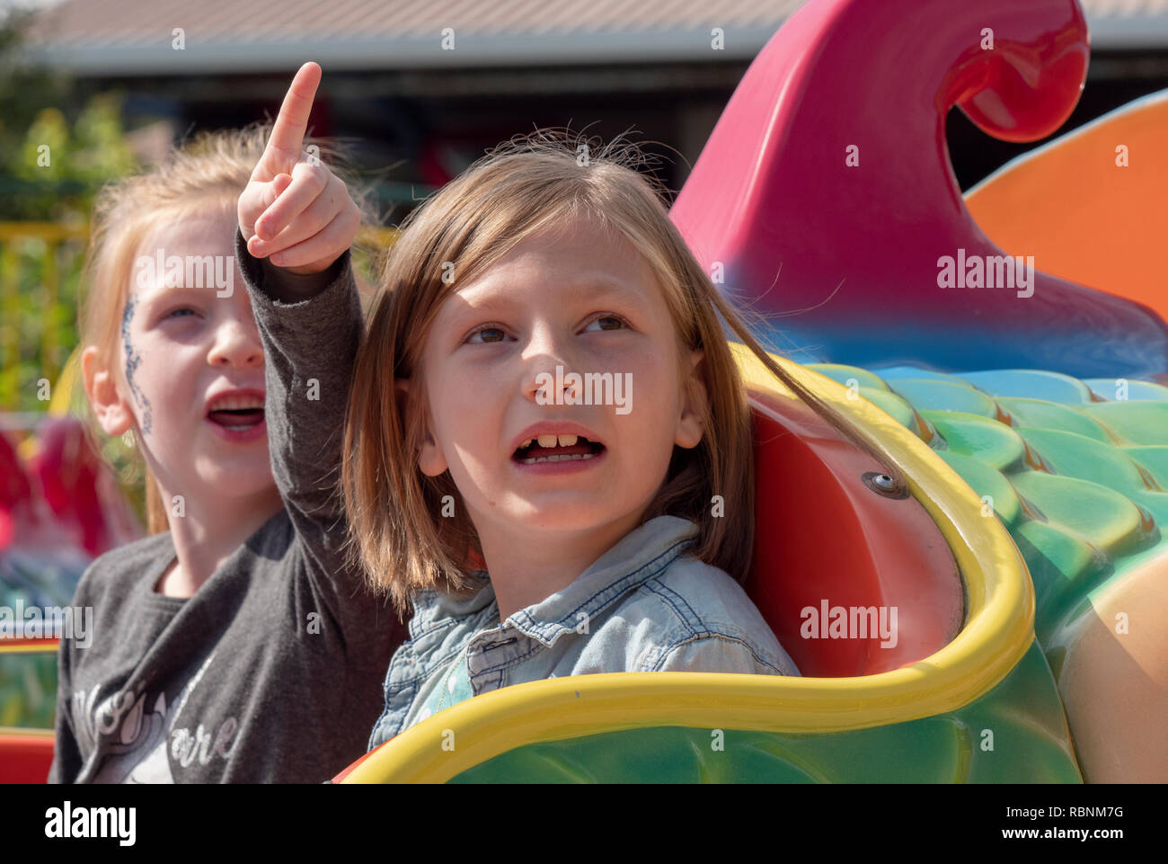 Two sisters 5years & 7years old enjoy the fun of a pleasure park. Stock Photo