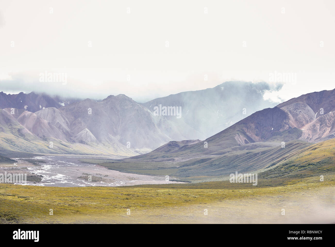 Dry River Bed Running Through Valley Between Mountains In Alaska Stock Photo