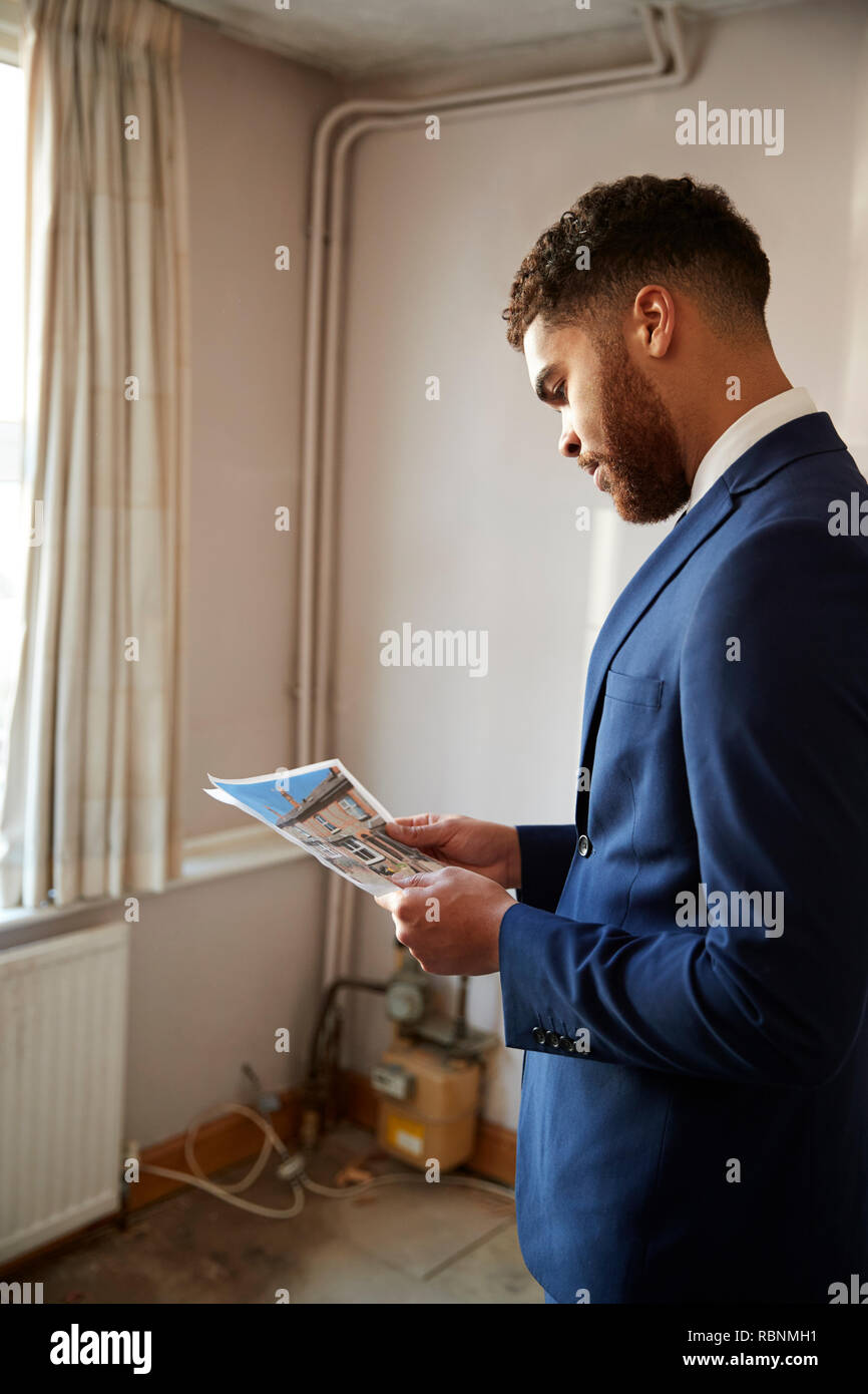 Male Realtor Looking At House Details In Property For Renovation Stock Photo