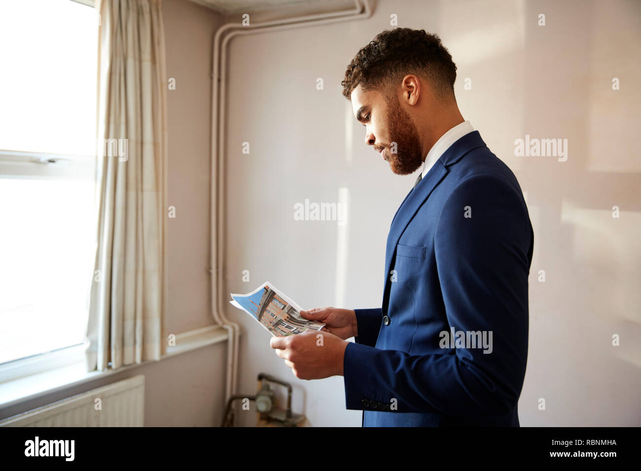 Male Realtor Looking At House Details In Property For Renovation Stock Photo