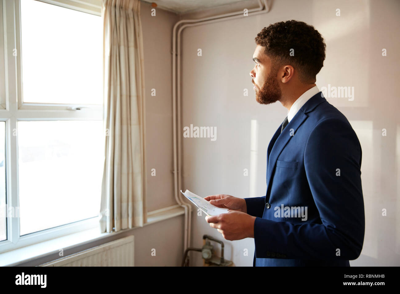 Male Realtor Looking At House Details In Property For Renovation Stock Photo