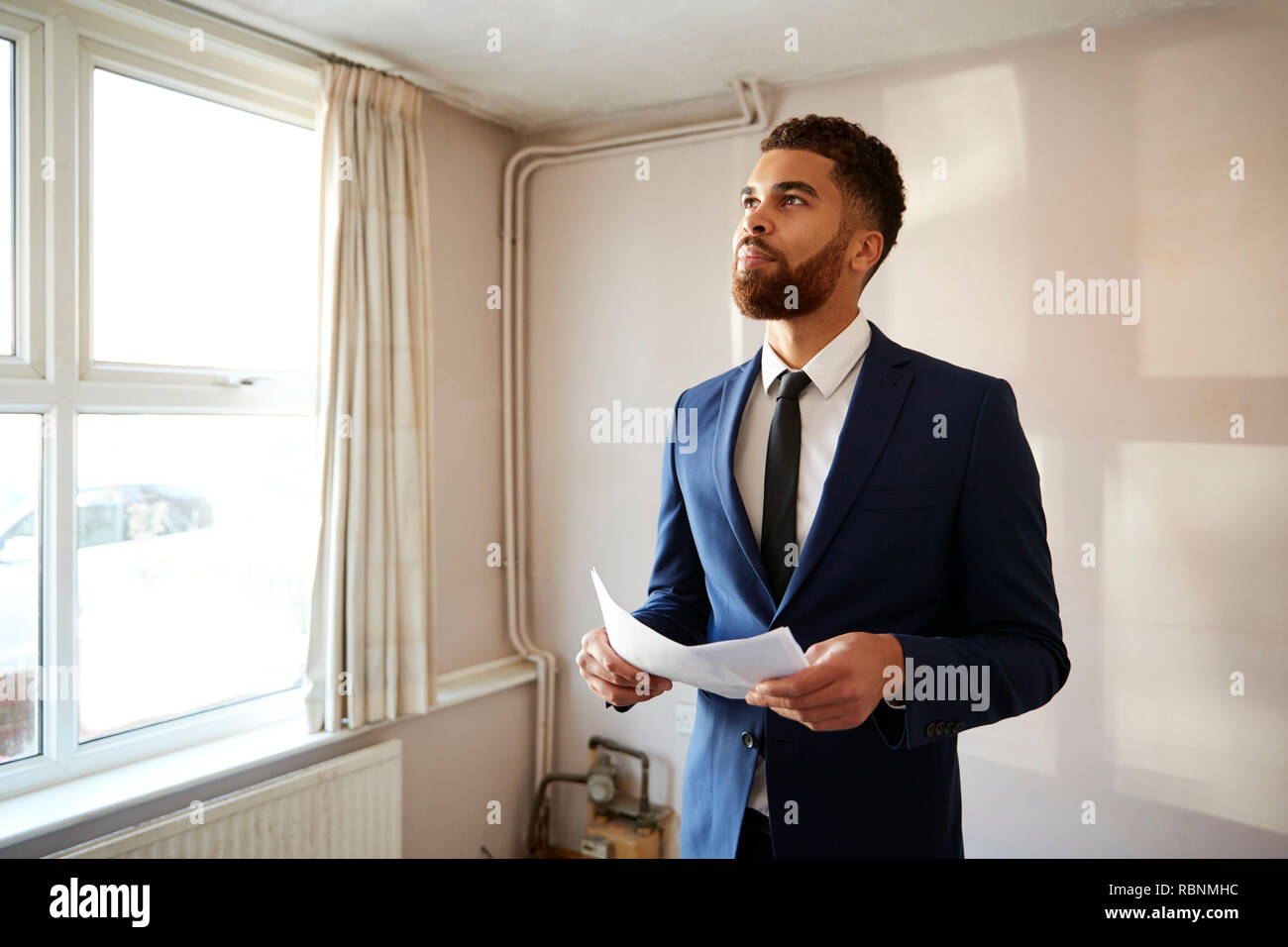 Male Realtor Looking At House Details In Property For Renovation Stock Photo