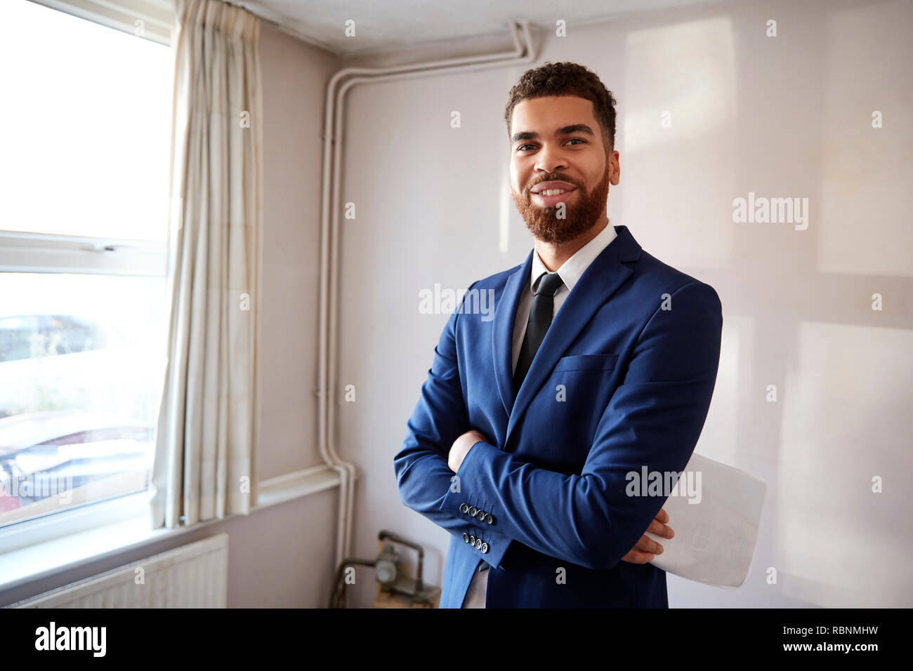 Portrait Of Male Realtor Looking At House Details In Property For Renovation Stock Photo