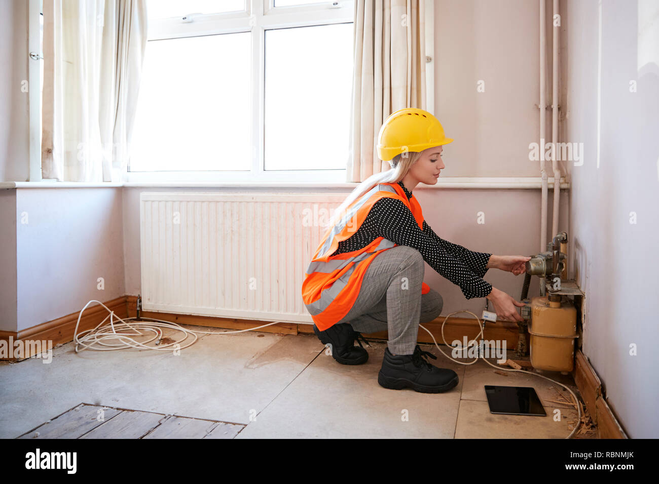 Female Surveyor In Hard Hat And High Visibility Jacket Checking Gas Supply Stock Photo