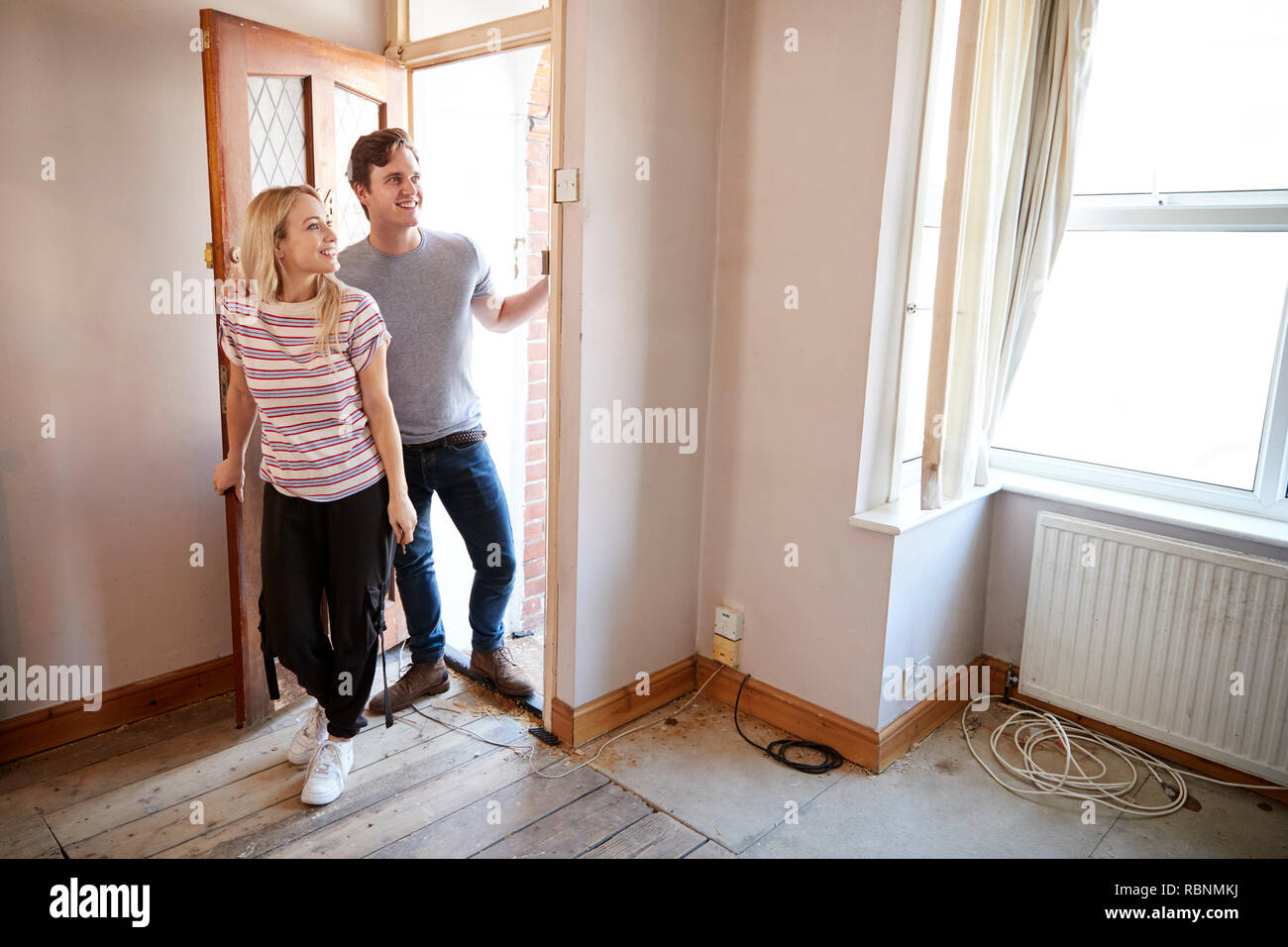 Excited Young Couple Opening Front Door Of New Home Stock Photo